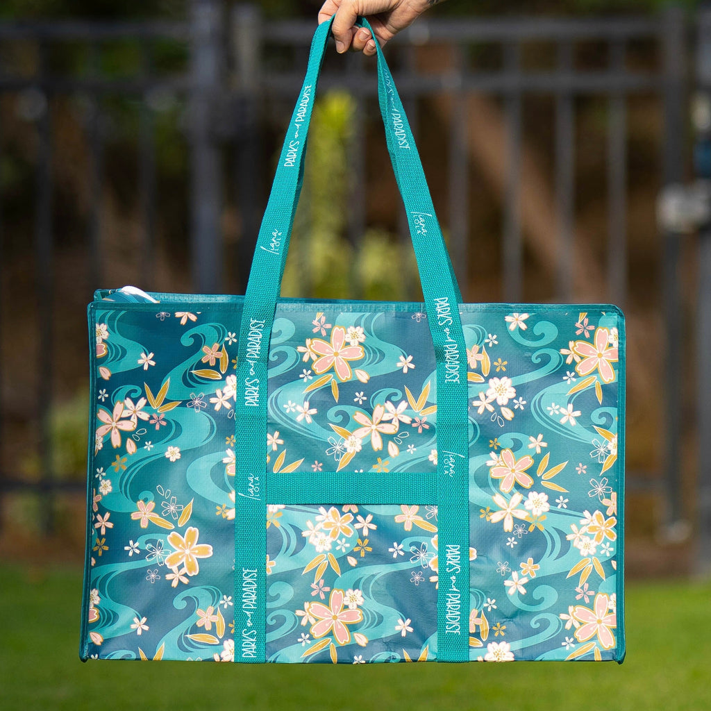 Tote bag with floral design held by a person outdoors